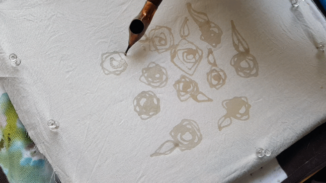 batiking. applying melted wax to linen fabric