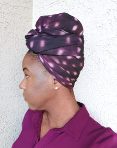 Side profile of model with purple spotted scarf tied around her head.